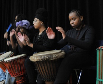 A group of women playing drums AI-generated content may be incorrect.