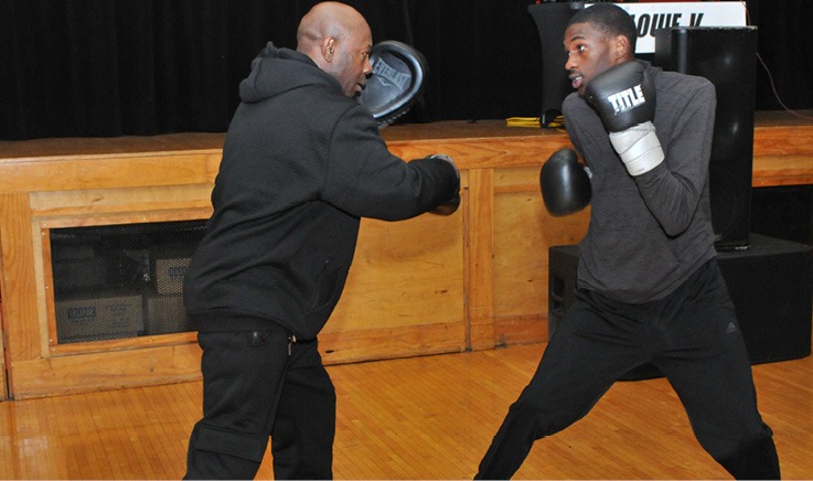 A person boxing with a person in black AI-generated content may be incorrect.
