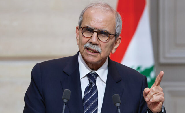 Lebanon’s PM: Negotiations with Israel do not mean normalization A man wearing a suit and glasses giving a speech. Description generated by AI