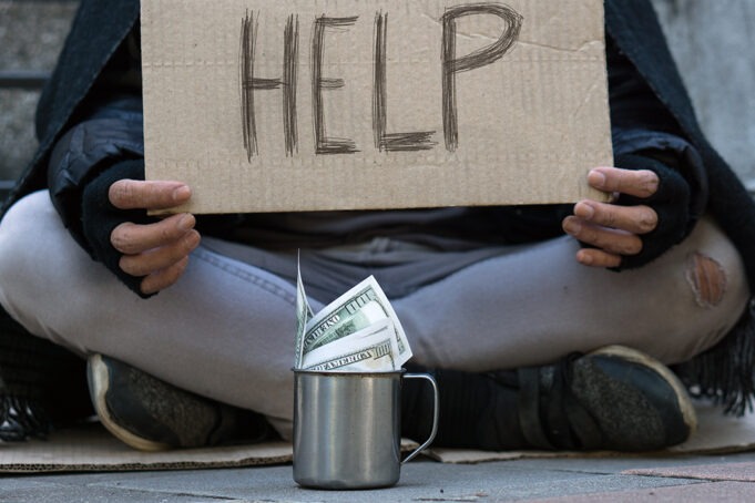 Beggar,Homeless adult man sitting on the street to get help. Ind