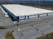 Maryland residents challenge warrantless ICE arrests in federal lawsuit A large industrial warehouse with a white roof and blue accents is surrounded by empty parking lots and roads in a rural area. Description generated by AI